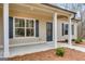 Close-up of the front entrance featuring neutral colored siding, white pillars and dark trim at 426 Ayers Rd, Bowdon, GA 30108