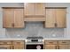 Close up of a stove and kitchen cabinets with a tile backsplash and stainless steel appliances at 426 Ayers Rd, Bowdon, GA 30108