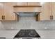 Modern kitchen featuring a stainless steel stovetop and herringbone backsplash at 426 Ayers Rd, Bowdon, GA 30108