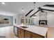 Open concept kitchen featuring a large island and adjacent living areas with beams and stone fireplace at 426 Ayers Rd, Bowdon, GA 30108