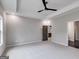 Spacious main bedroom with tray ceiling, fan, and view into ensuite bathroom at 426 Ayers Rd, Bowdon, GA 30108