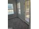 Cozy living room featuring neutral walls, gray carpet, windows, and access door to sunroom at 1601 Celestial Ct, Mcdonough, GA 30253