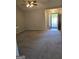 Open living room with neutral carpet, ceiling fan, and an open door leading outside at 1601 Celestial Ct, Mcdonough, GA 30253