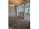 Open-concept living room featuring neutral paint, gray carpet, and traditional lighting fixtures at 1601 Celestial Ct, Mcdonough, GA 30253