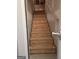 Unfinished basement stairs with plywood steps and a wooden handrail against a light colored wall at 1601 Celestial Ct, Mcdonough, GA 30253