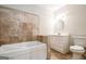 Bathroom features soaking tub with tile accent wall and vanity with white cabinets at 849 Wagon Wheel Cir, Fayetteville, GA 30214