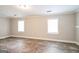Spacious bedroom with wood-look flooring, neutral walls and trim, and two large windows at 849 Wagon Wheel Cir, Fayetteville, GA 30214