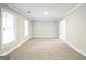 Spacious living room with neutral paint, carpet, and natural light from two windows at 849 Wagon Wheel Cir, Fayetteville, GA 30214
