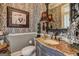 Powder room with decorative wallpaper, marble countertop and statement mirror and vanity at 1064 Highway 20 E, Mcdonough, GA 30252