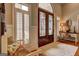 Elegant foyer with ornate double doors, plantation shutters, and a cozy bench for a welcoming entrance at 1064 Highway 20 E, Mcdonough, GA 30252