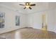 Spacious main bedroom with tray ceiling, ceiling fan, and wood-look flooring at 3863 Meeting St, Duluth, GA 30096