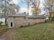 Brick home's backyard with a modest lawn and access door, blending indoor-outdoor living at 2825 Battlecrest Dr, Decatur, GA 30034