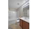 Bright bathroom with wood vanity, white sink, and white tiled shower and tub at 5828 Union Walk Dr, Union City, GA 30291