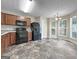 Bright kitchen featuring black appliances, wooden cabinetry, and adjacent dining area with large windows for ample light at 5828 Union Walk Dr, Union City, GA 30291