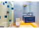 Bright bathroom with a glass shower with blue accent tiles, vanity, and lighting at 242 Kirkley Rd, Tyrone, GA 30290