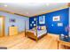 Bright blue bedroom features wood trim, hardwood floors and a traditional four-poster bed at 242 Kirkley Rd, Tyrone, GA 30290