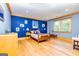 Spacious light blue bedroom with wooden floors, a four-poster bed, and natural light at 242 Kirkley Rd, Tyrone, GA 30290