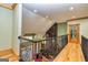 Hallway view of open living space with wrought iron railing, natural lighting, and hardwood floors at 242 Kirkley Rd, Tyrone, GA 30290