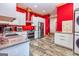 Modern kitchen features sleek cabinetry, stainless steel appliances, and striking red accent wall at 242 Kirkley Rd, Tyrone, GA 30290