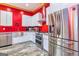 Bright kitchen with stainless steel appliances, farm sink, modern cabinets and vibrant red accent wall at 242 Kirkley Rd, Tyrone, GA 30290