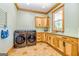 Functional laundry room with stainless steel washer and dryer, ample cabinetry, and a window view at 242 Kirkley Rd, Tyrone, GA 30290