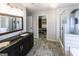 Well-lit bathroom featuring a dual vanity, walk-in shower, and a spacious walk-in closet at 5479 Dorsett Shoals Rd, Douglasville, GA 30135