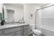 Modern bathroom featuring a granite countertop, a mirror, white toilet and combined shower and tub at 11517 Kimberly Way # 3, Hampton, GA 30228
