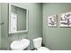 Small half bathroom with green walls, a decorative mirror, and framed art at 11517 Kimberly Way # 3, Hampton, GA 30228