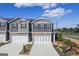 Charming townhomes feature a brick and siding exterior, two-car garages, and a landscaped front yard with a blue sky background at 11517 Kimberly Way # 3, Hampton, GA 30228