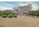 Elegant two-story brick home with lush landscaping and a well-maintained front lawn on a sunny day at 355 Woodbyne Dr, Fayetteville, GA 30214