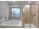 Bright bathroom featuring a tiled shower, soaking tub, and a frosted window allowing natural light at 1709 Goodwin Dr # 29, Hampton, GA 30228