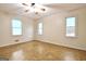 Well-lit bedroom featuring parquet floors, a ceiling fan, and three large windows at 435 Crabapple Rd, Fayetteville, GA 30215