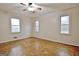 Inviting bedroom featuring parquet floors, a ceiling fan, and three large windows at 435 Crabapple Rd, Fayetteville, GA 30215