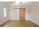 Bright bedroom featuring parquet floors, a ceiling fan, and a wood-look sliding barn door at 435 Crabapple Rd, Fayetteville, GA 30215