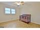 Sunlit bedroom boasting parquet flooring, a large window, and a classic wood crib at 435 Crabapple Rd, Fayetteville, GA 30215