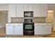 Bright kitchen with white cabinets, stainless appliances, and a mosaic tile backsplash at 435 Crabapple Rd, Fayetteville, GA 30215