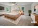 Spacious main bedroom with a wooden bed frame, side tables, and two windows with natural light at 120 Black Rock Ct, Fayetteville, GA 30214