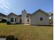 Back exterior features a spacious backyard with a patio and light siding at 6195 Winston Trce, Mcdonough, GA 30252