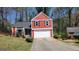 Charming two-story home with red siding, black shutters, and a well-manicured lawn at 7472 Woods Ct, Lithonia, GA 30058