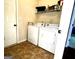 Functional laundry room with a washer, dryer, storage shelf, and convenient access door at 80 Tanners Ct, Covington, GA 30016
