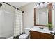 Functional bathroom with a shower/tub combo, wood vanity, framed mirror, and neutral design at 5760 Winding Lakes Dr, Cumming, GA 30028