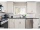 White shaker cabinets, gray countertops, and stainless steel dishwasher at 8816 Ashwood Dr, Riverdale, GA 30274