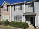 Two-story townhome with brick and gray siding, landscaping, and a walkway at 103 Odyssey Turn, Conyers, GA 30012