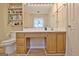Bathroom including a mirror, sink with vanity, open storage shelf, and toilet at 2020 Moore Rd, Moreland, GA 30259