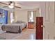 Cozy bedroom with a comfortable queen-sized bed, a ceiling fan, and natural light from the windows at 2020 Moore Rd, Moreland, GA 30259