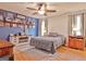 Bedroom featuring a window, dresser, fan, light, rug, and a decorative accent wall at 2020 Moore Rd, Moreland, GA 30259