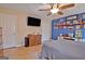 Bedroom with a ceiling fan, closet, wood flooring, and decorative display wall at 2020 Moore Rd, Moreland, GA 30259