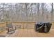 Back deck with seating area and grill overlooking the natural wooded landscape at 2020 Moore Rd, Moreland, GA 30259