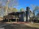 Charming home with a wooden deck and a landscaped yard surrounded by mature trees at 2020 Moore Rd, Moreland, GA 30259