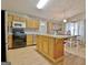 Bright kitchen with wooden cabinets, an island with seating, black appliances, and modern lighting at 2020 Moore Rd, Moreland, GA 30259